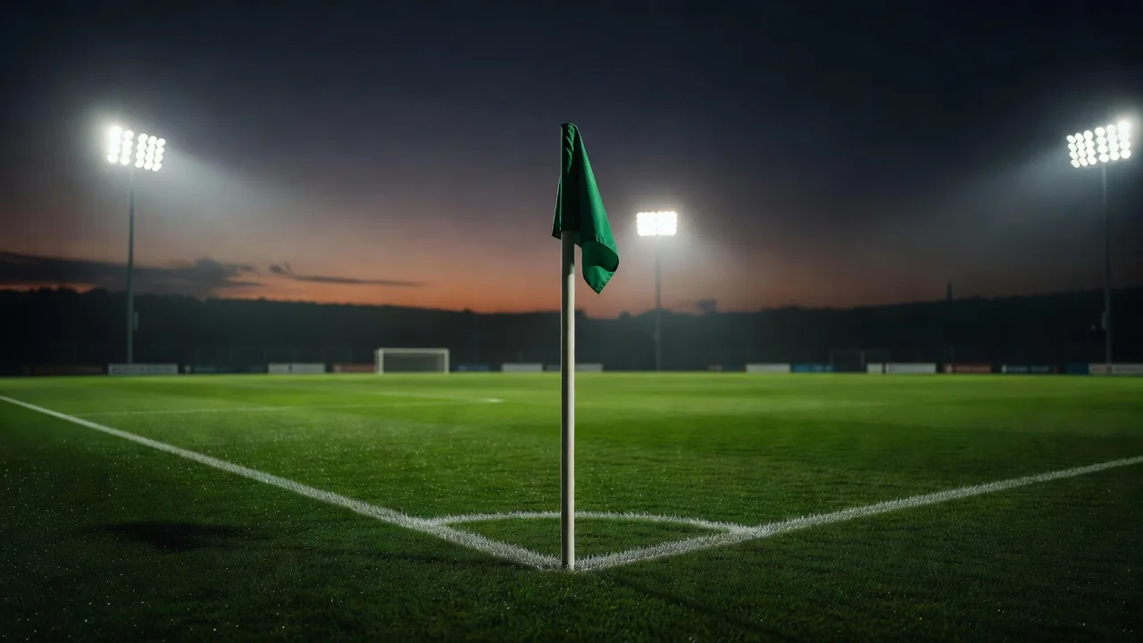Bandeira de escanteio em gramado ao entardecer com luzes de estádio