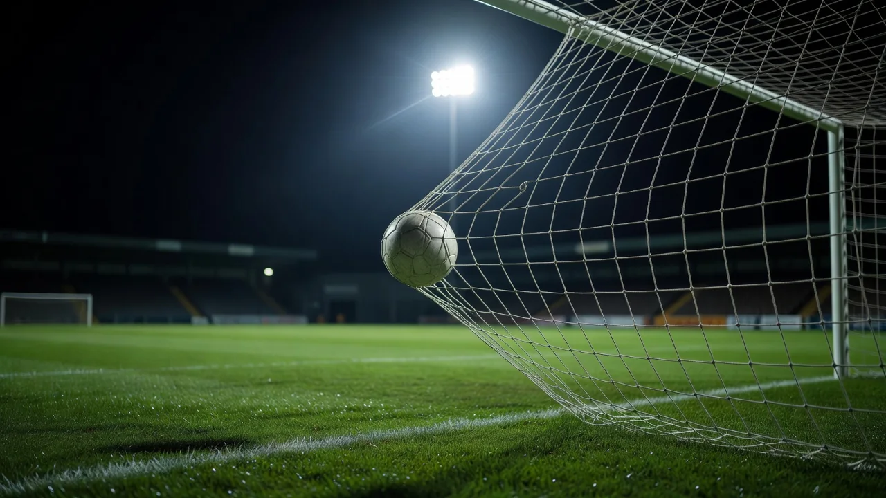 Bola de futebol estufando a rede do gol em noite de jogo